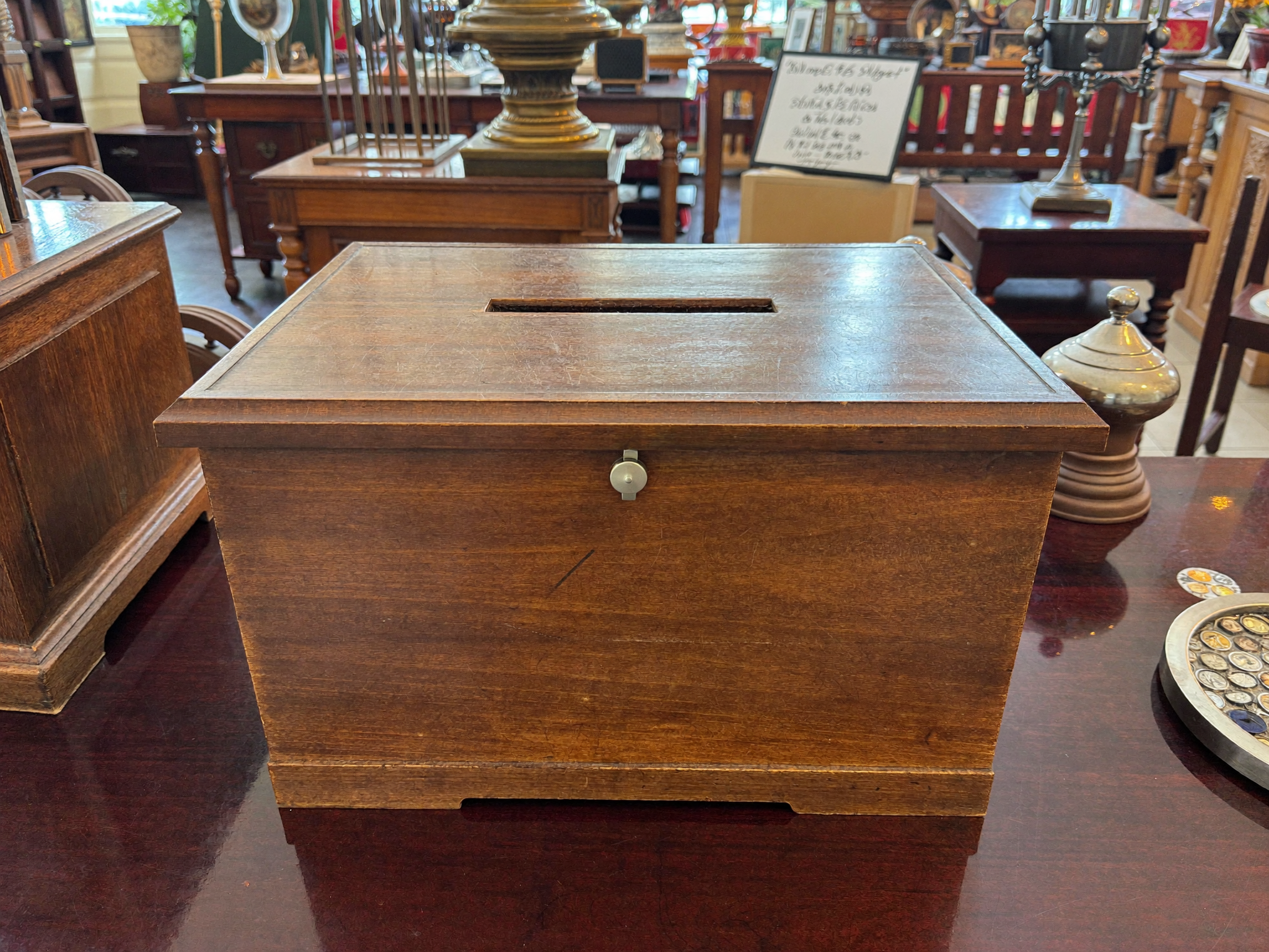 Elegante hoelzerne Spendenbox mit Muenzschlitz auf einer Theke im Ausstellungsraum