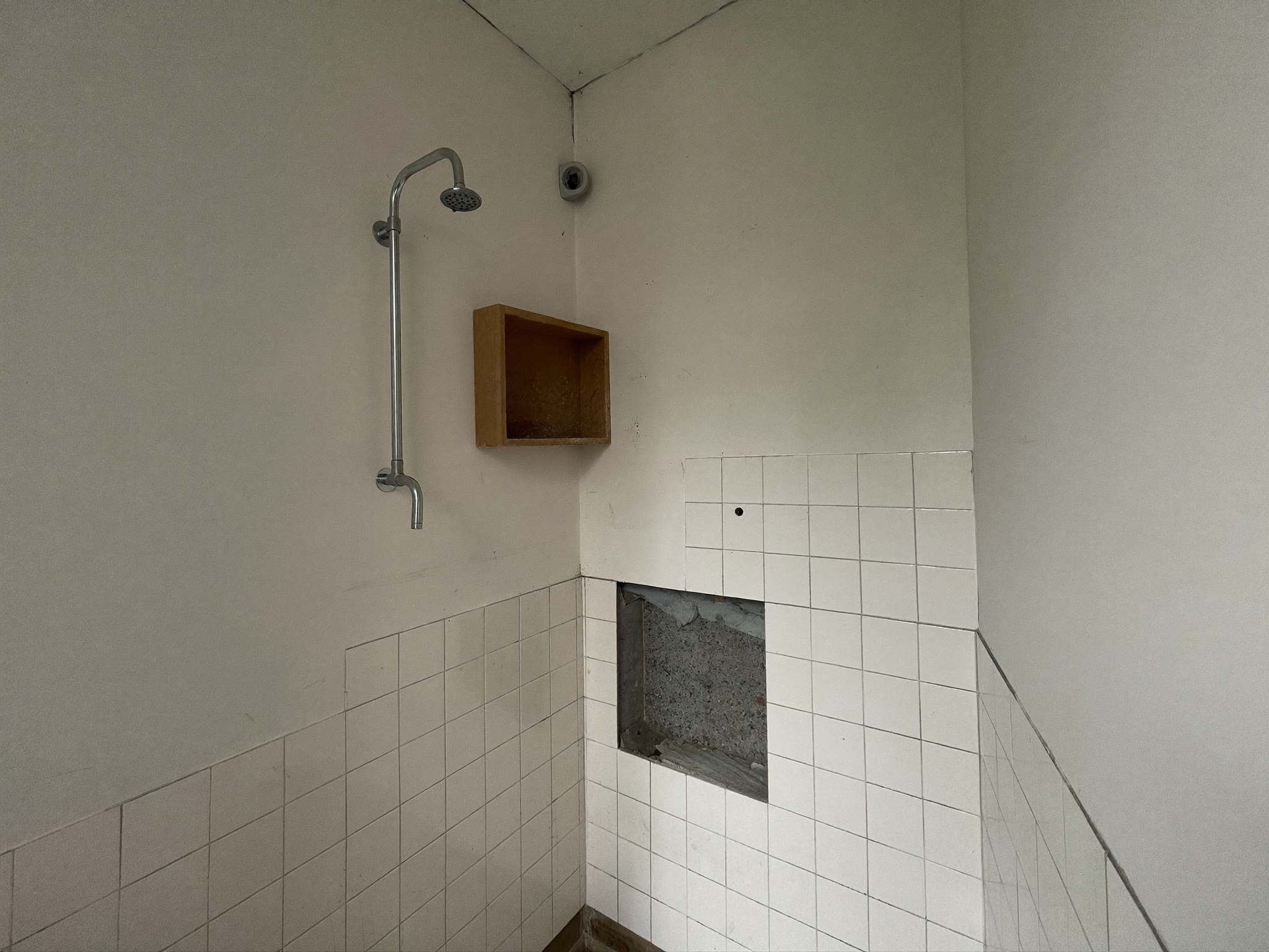 Entkerntes Badezimmer mit nackten Wänden und freiliegenden Leitungen