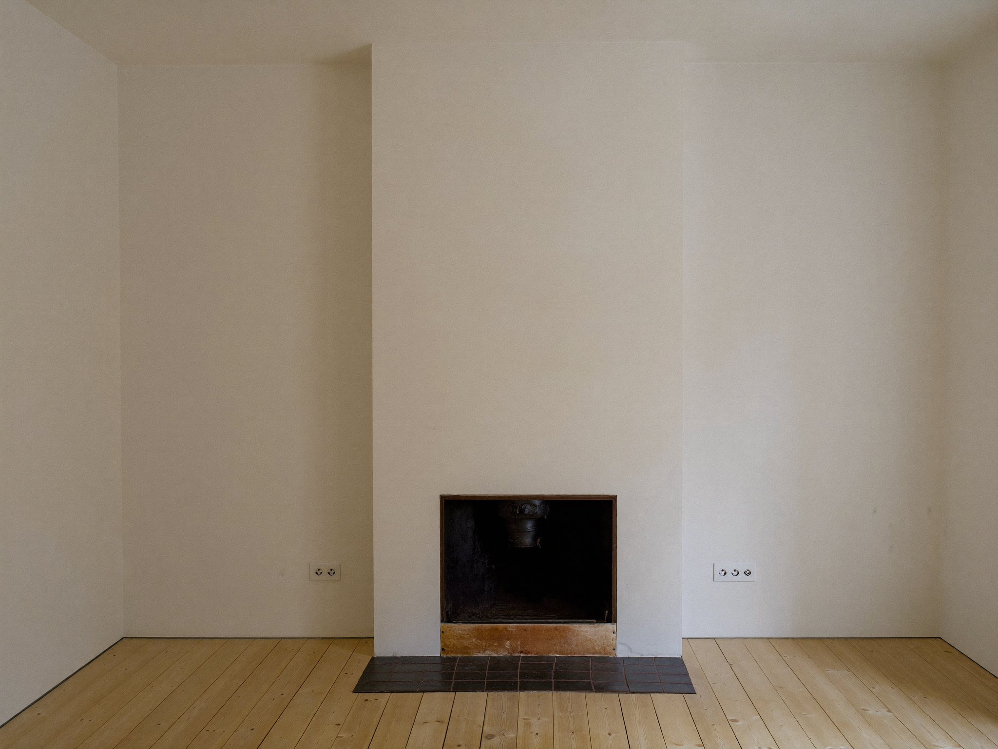 Renovierte Wohnzimmerecke mit sauberer leerer Wand nach Ofenentfernung