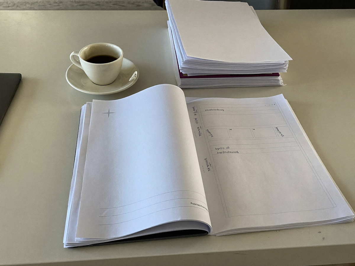 Aufgeräumter Schreibtisch mit Laptop, Tasse und sortierten Unterlagen
